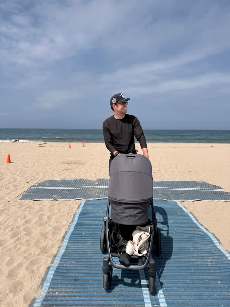 Eric Tribe walking with a stroller on the beach